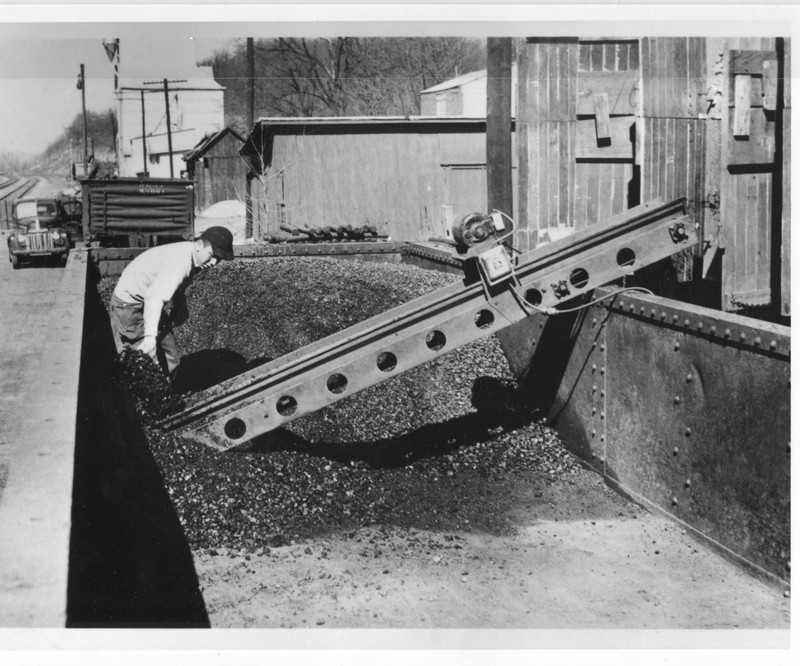 Photo of student shoveling coal into chute.