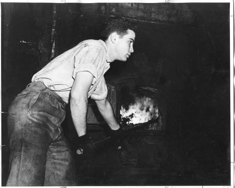 Student loading coal into the furnace.