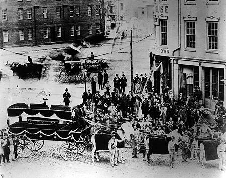 Funeral carriage traveling to the statehouse. Also possibly staged afterwards.