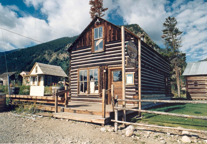 In the early  years of the Frisco Historic Park, local crafters and artisans set up shop in the historic buildings. The sign out front reads "Wildflower Natural Foods- The Loft Pottery". 