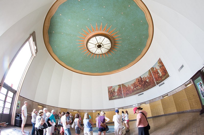 Tourists on a Miami Beach Art Deco tour admire the post office's mural and unique ceiling art.  
