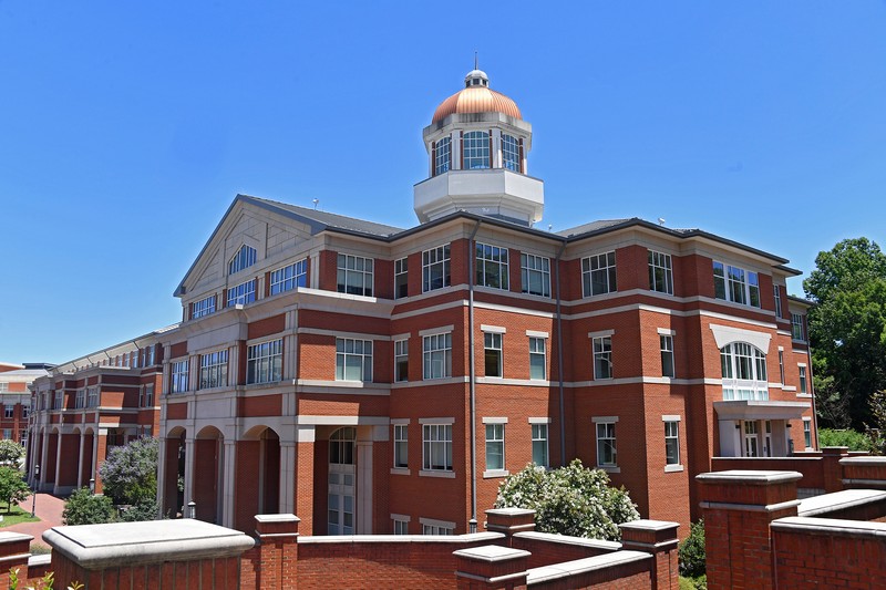 Red brick, four story academic building with a copper-topped cupola