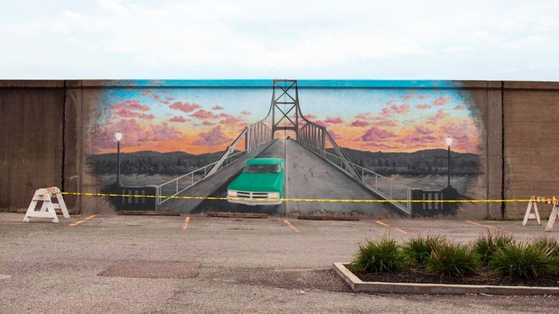 In 2018 a mural depicting the Silver Bridge was painted on the floodwall in front of the memorial. Image obtained from the Historical Marker Database.