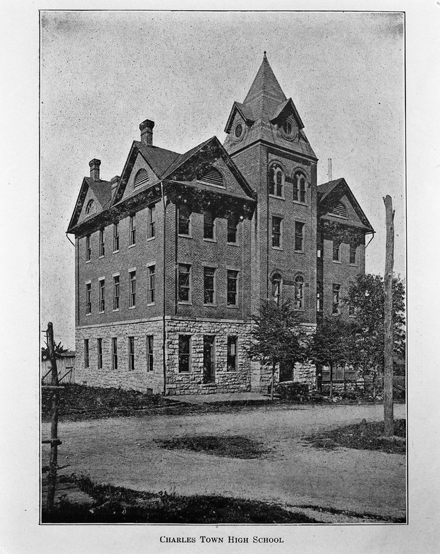 The building as Charles Town High School, with the original steeple roof on the tower. The steeple roof was replaced with the current pyramidal design in 1930.