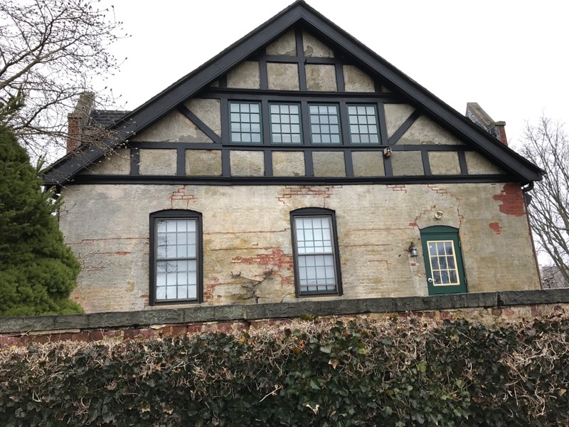 Wallace Hall side view. Wooden beams, stucco surfaces, and steeply pitched roof are shown, which are other common features of Tudor Revival Style. 