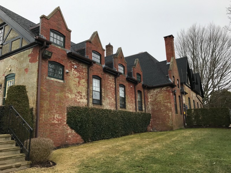 Wallace Hall side view. Exposed brick surfaces, steeply pitched roofs and long windows are shown.