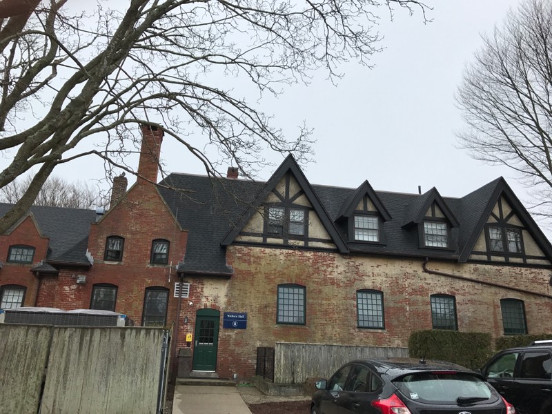 Wallace Hall rear view. Many chimneys, brick and stucco surfaces, steeply pitched roof, and beams shown. All of these are common features of Tudor Revival Style Homes. 