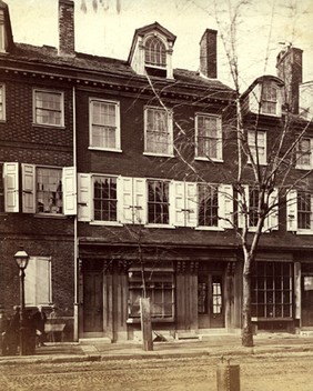 Front of House of Industry, photographed from street. The second floor windows have shutters, and fourth-floor dormers are visible between chimneys.