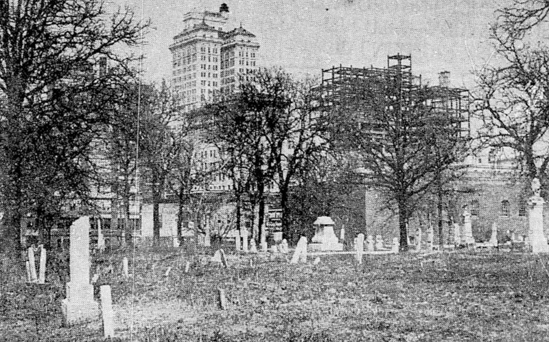 This old photo of the cemetery shows the city growing up around it. The tall structure in the background is the Magnolia Building.
