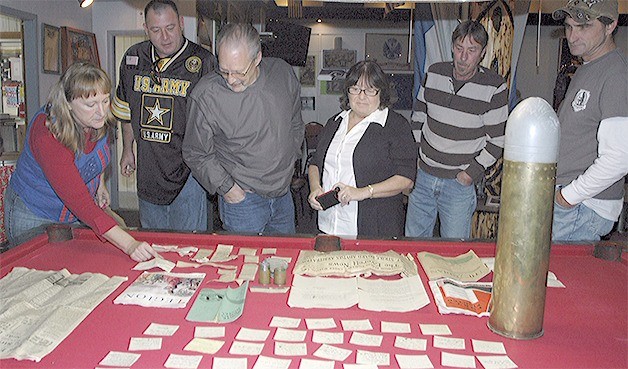 Members of American Legion Post 76 looking at the contents of the time capsule found within an artillery shell from 1943. (Kirk Boxleitner/Arlington Times)