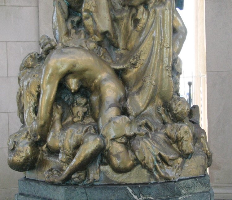 Lower view of Lady Liberty with dead men at her feet.