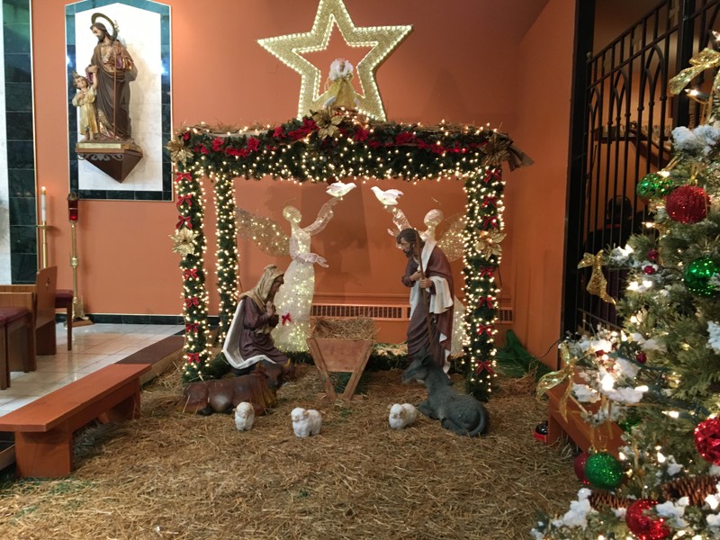 Decorated manger to the right of altar and Christmas tree