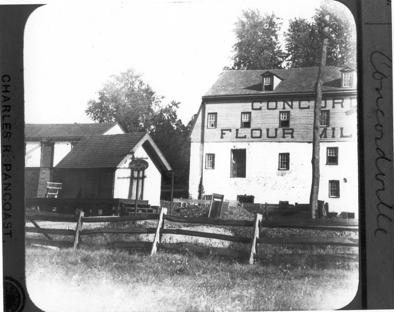 Black and white image of the north side of the grist mill, with railroad in the foreground.