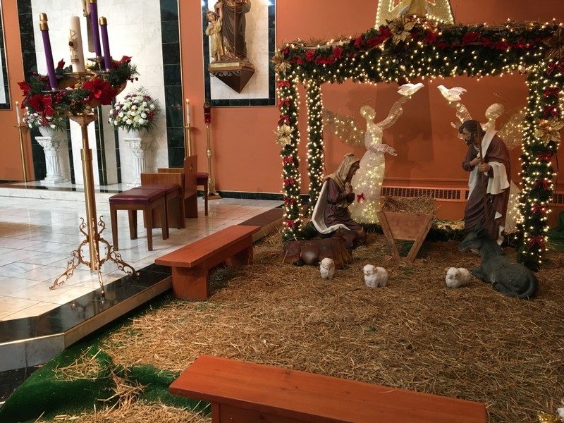 View of manger as well as side of altar with Advent wreath and candles