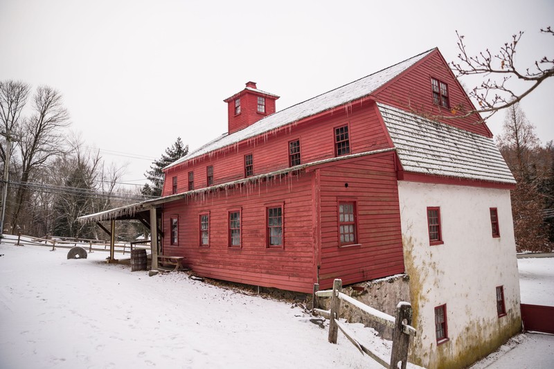 Image of a single story frame addition with red-painted siding attached to the Grist Mill.