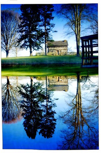 by Robert McWhorter The cabin's image is reflected in the Jackson’s Mill Pond, which is used to power Blaker’s Mill.
