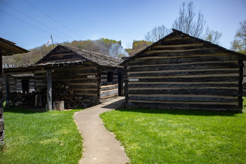 A path leads to the log Trading Post on the right and Meeting House on the left.