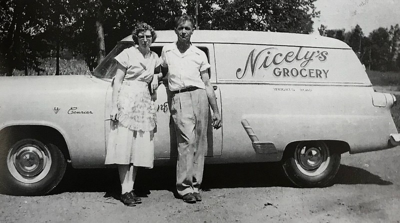 Imelda and Helmer stand next to Nicely Grocery Store Delivery Truck in the 1950s