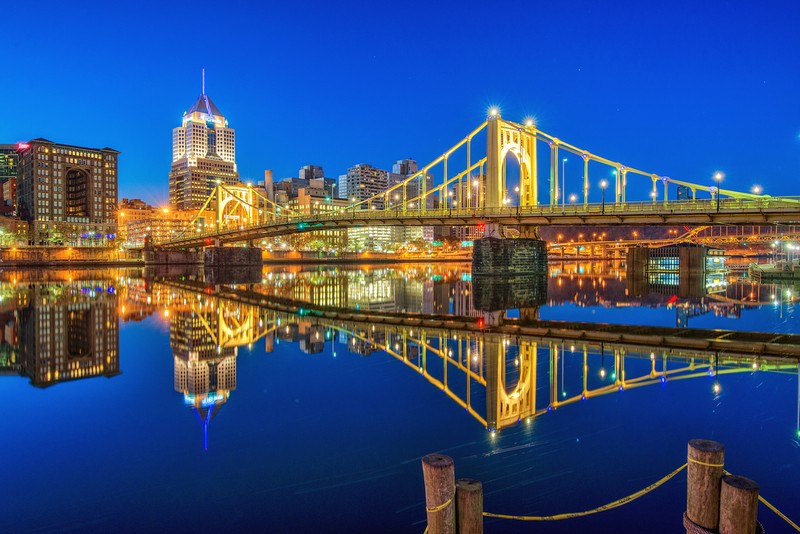 The Clemente Bridge is reflected in the waters of the Allegheny River.  Architectural lighting was added to the bridge in 2002.  