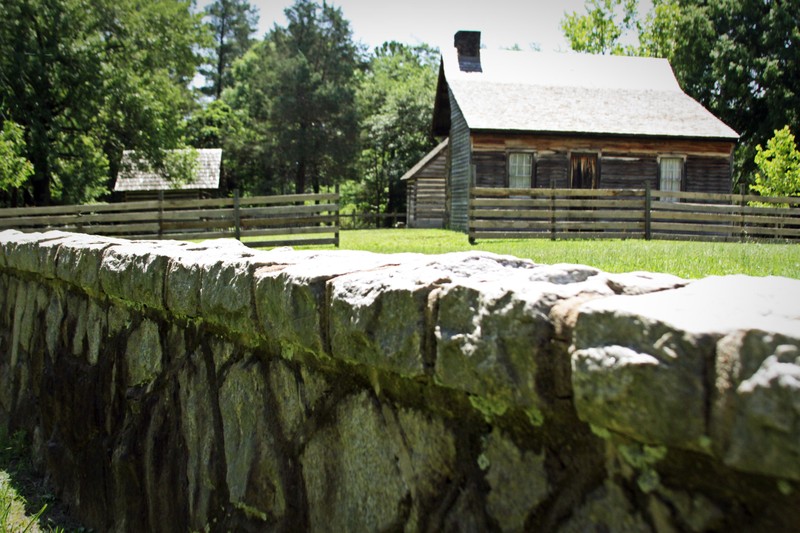 A view from outside the Bennett Farm. 
From left to right: Smokehouse, Bennett House. 