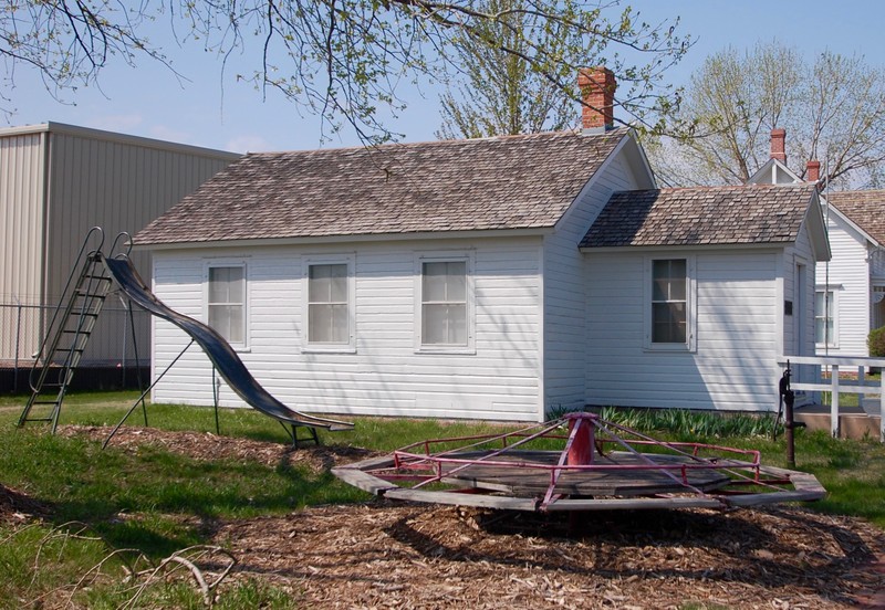 Side view of the schoolhouse and playground equipment. 