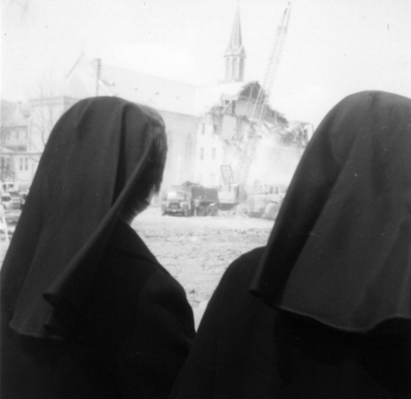 Two sisters watch the demolition of the motherhouse in 1975.