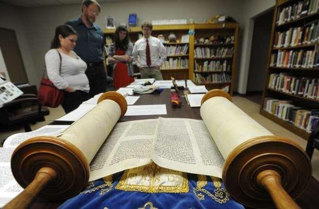 Member of the Temple of Israel overlook the Torah.