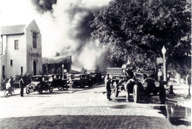 Firefighters and fire engine fighting a fire at the Hart Rug Co. on S. Ft. Harrison St. in Clearwater, Florida, April 28, 1926. 