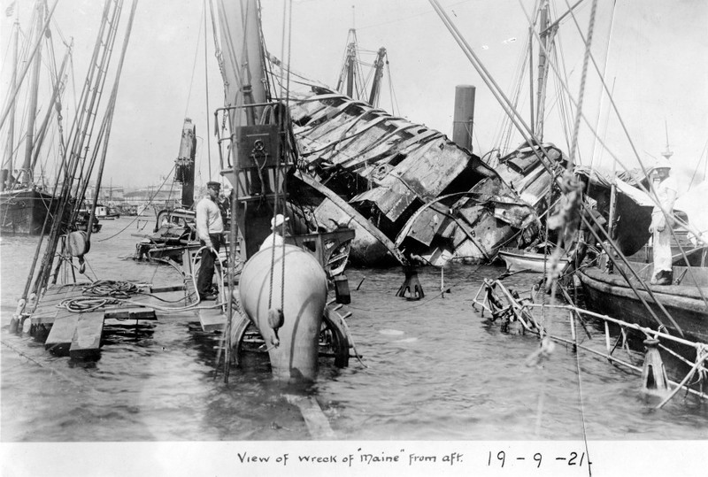 U.S. Navy diving crew at work on the ship’s wreck, in 1898, seen from aft looking forward. U.S. Naval Historical Center Photograph.