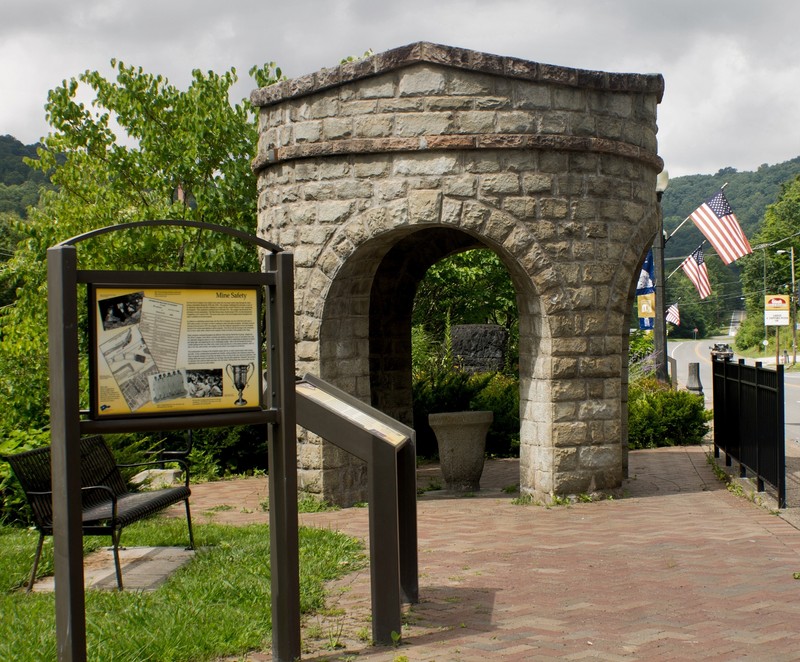 Stone fountain with interpretive signage visible.