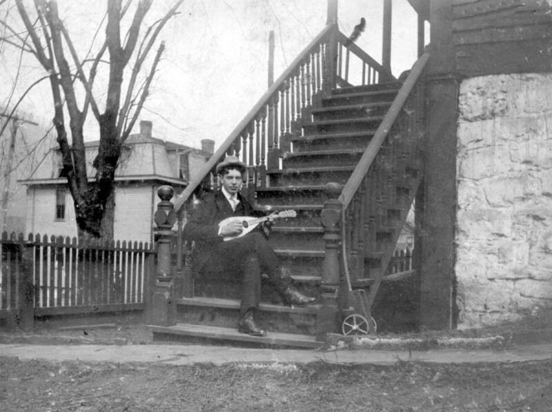 A musician on the steps of the house.