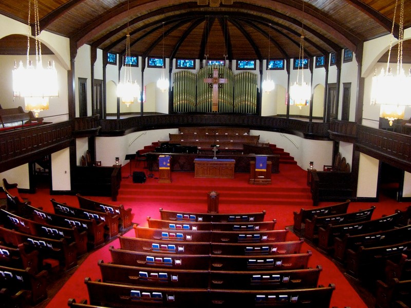 The impressive interior features original pews, an organ, and a beaded board wooden ceiling.