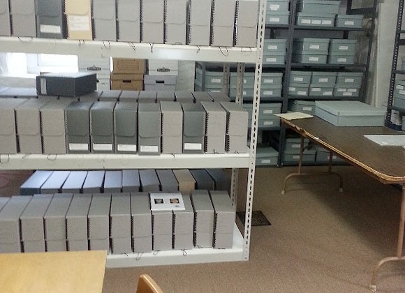 Image of room with shelving holding archival boxes.