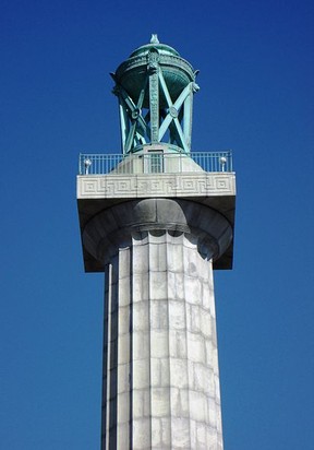 A close-up of the decorative lantern atop the monument 