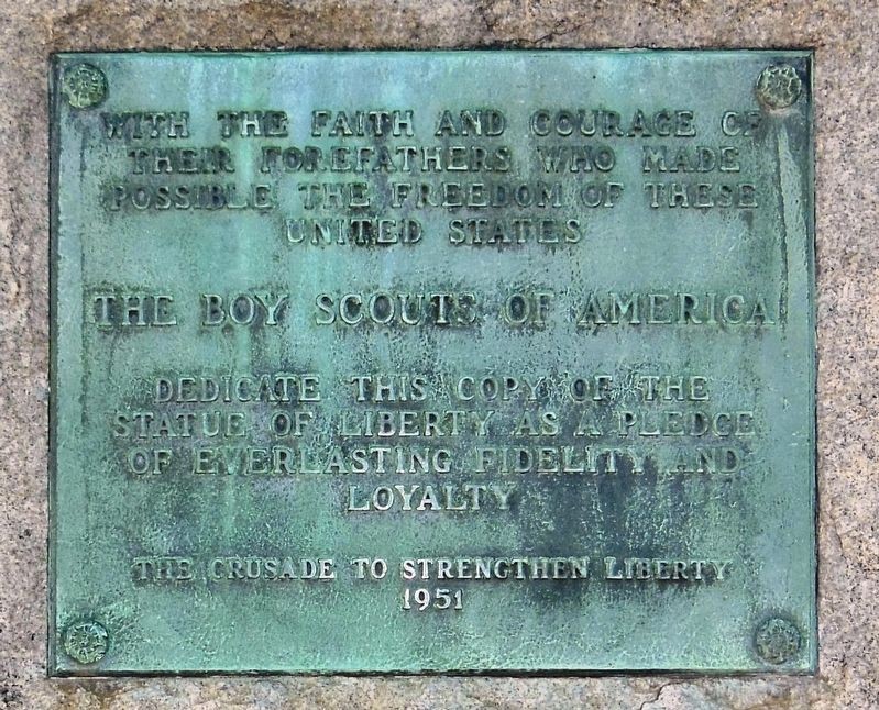 Close-up photograph of the plaque beneath the Statue of Liberty Replica.