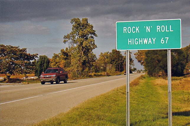 A colored photo of a sign on the side of the road.