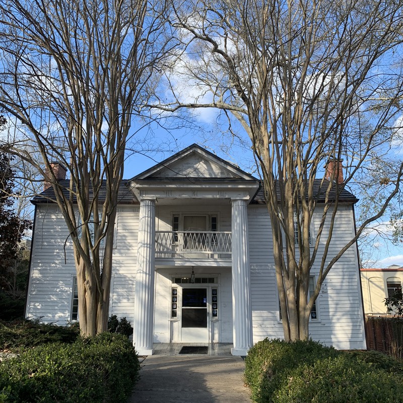 Exterior of the white house with a blue sky and clouds.