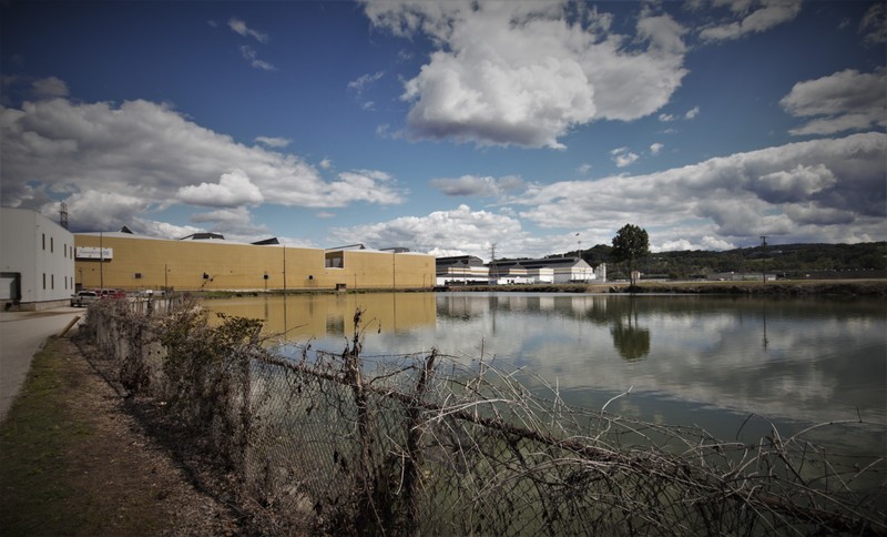 Present-day view, looking southeast. The tan-colored buildings on the left were also once part of the NOP, but have made auto parts since the 1970s.  In the 1960s, FMC tested vehicles in the pond area in foreground. Photo K. Warmack.