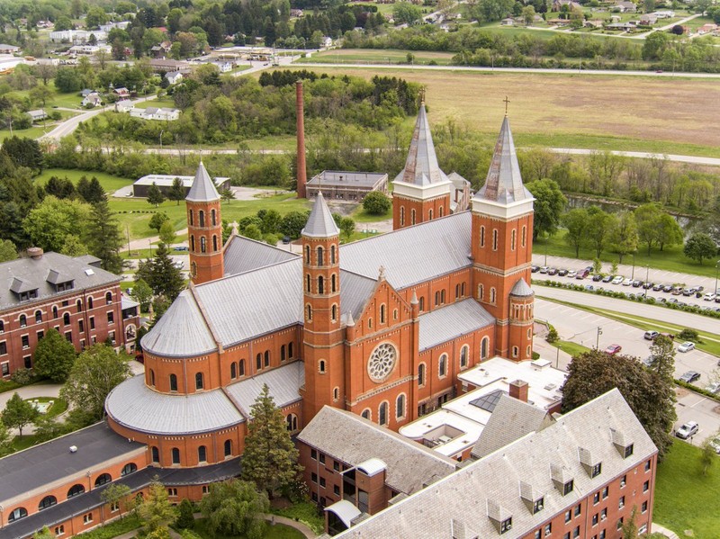 Saint Vincent Basilica has Romanesque Revival design, shown best in the rounded arch windows, and is shaped like a cross. 