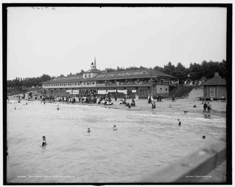 Image of park-goers swimming in Lake Erie with a bathhouse structure in the background (black and white) 