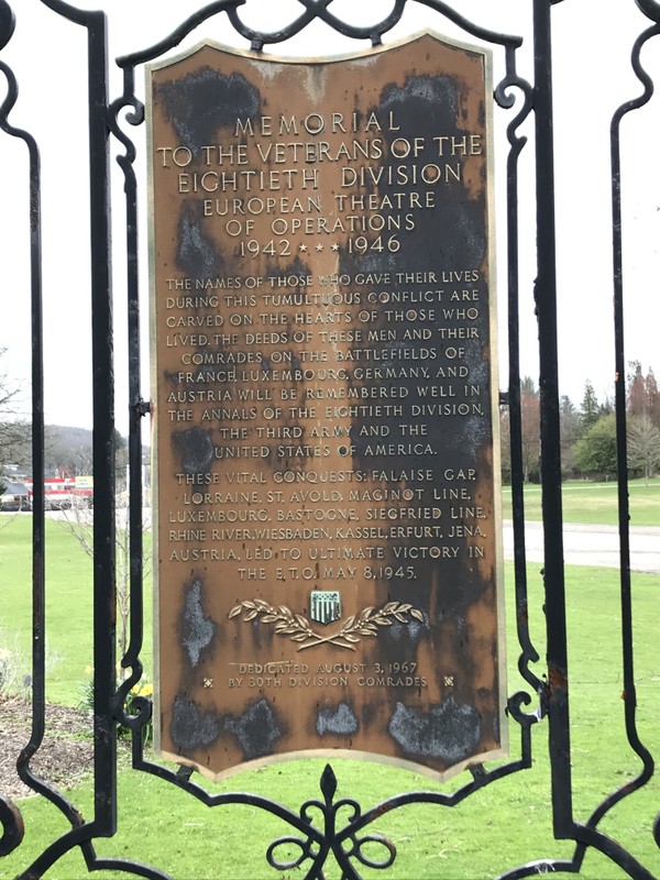 A bronze plaque mounted behind the cannon, which is titled "Memorial to the veterans of the eightieth division, European theatre of operations, 1942-1946"