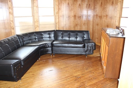 Interior of Mayfield house with black leather 70s style sectional