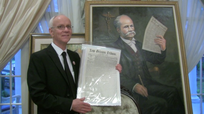 Historian Mark Roudane poses with a portrait of his Great, Great Grandfather, Dr. Louis Roudanez, founder of The New Orleans Tribune, the city's first Black daily newspaper.  