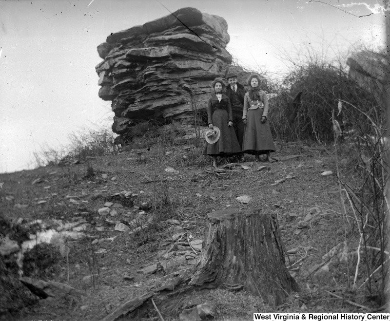 An undated photo showing two women and a man beside Sky Rock. 