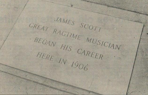 James Scott marker in sidewalk in front of building at this location.