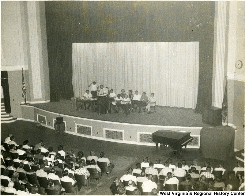 Group seated on the stage of the Morgantown High School auditorium before an audience. Date unknown. Courtesy of the West Virginia and Regional History Center. 