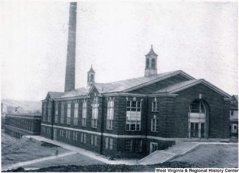 View of the interior facade of "shop" building featuring the tall smokestack. Date unknown. Courtesy of West Virginia and Regional History Center.