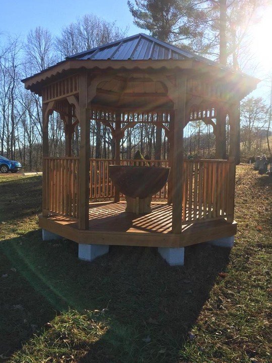 Gazebo housing the salt kettle under which a young Lucy Downs hid herself during an attack from Native Americans. The salt kettle itself looks like a rather large iron bowl, aged by rust and patina. Photo Courtesy: Linda Wellman