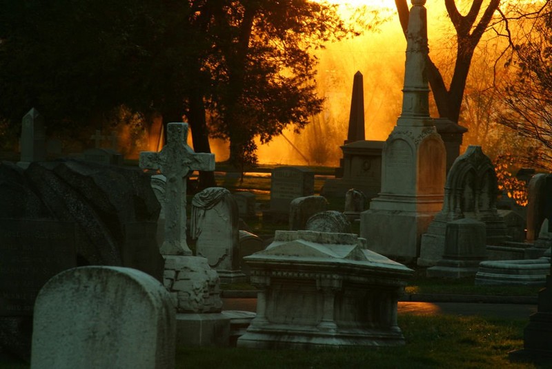 The sun rises on the funerary art at the Woodlands cemetery.