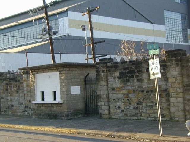 A closer view of the stone wall and ticket booth on F. Street, with the Charleston Ordnance Center in background. Photo by Bob Lilley.